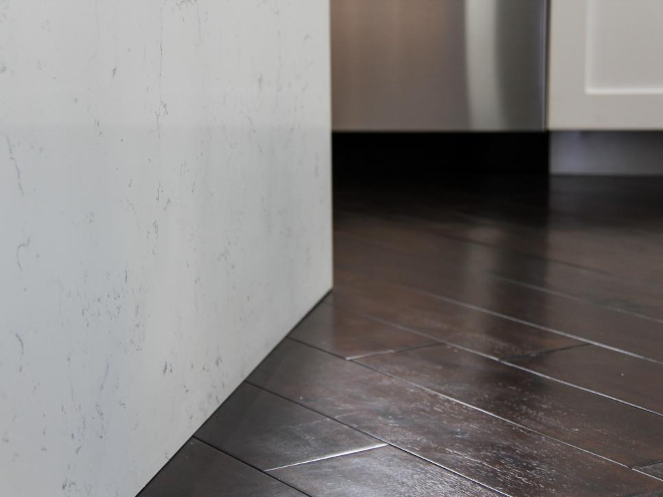 Dark Hardwood Floors with White Quartz Waterfall Countertop