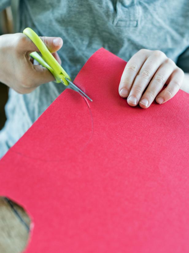 Scissors Cutting Red Construction Paper Into Semicircle