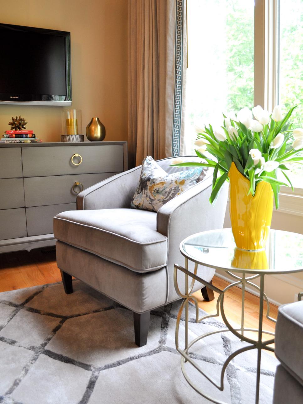Grey and beige transitional bedroom seating area with a yellow vase.