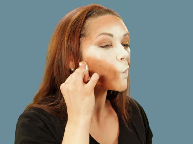 For enviable Halloween cat makeup, get the perfect base by using a makeup sponge to apply foundation that is several times lighter than your skin to the nose, middle of the forehead, under the eyes, along the cheeks and down the chin. Use a different makeup sponge and apply dark orange-brown foundation to all the areas not covered by the light foundation. Use a third sponge and lightly blend where the two colors meet. Use black eyeliner to fill in the brows. Add sharper angles over the middle of the eyes to create a dramatic peak. Heavily line the bottom lash line and extend the line out past the eye. Inside, extend the line a little down the inside of the nose. Line the top lash line and on the inside corner of the eye. Extend the top line to meet the bottom line. With the pencil, cover the eyelid, extending out beyond the eye. Blend the lines with a small, flat makeup brush to make them smooth.