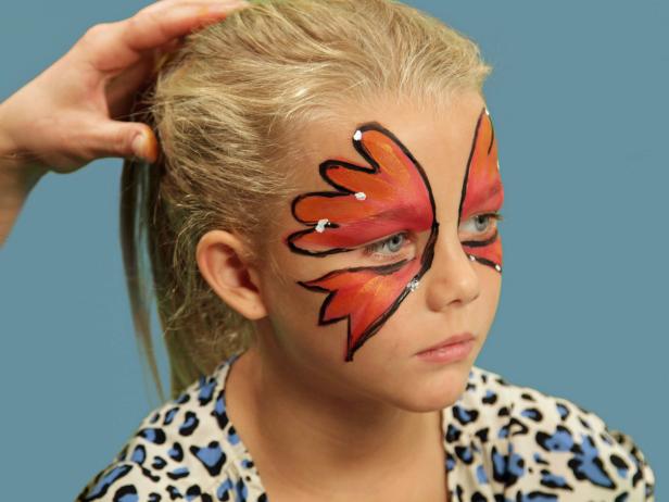 To transform your child or yourself into a beautiful butterfly for Halloween, create one large wing over each eyelid and up the forehead using face paint and a wide brush. Use black liquid eyeliner and line the edge of the makeup. To add highlights to the wings, use white face paint and a small makeup brush to randomly dot white on each wing tip, right on top of the black lines. Also, add a dot to the inside of the eye. Use your fingers and carefully apply some kid-friendly gel glitter inside the black lines on the wings. Be sure to keep the glitter away from the eyes.