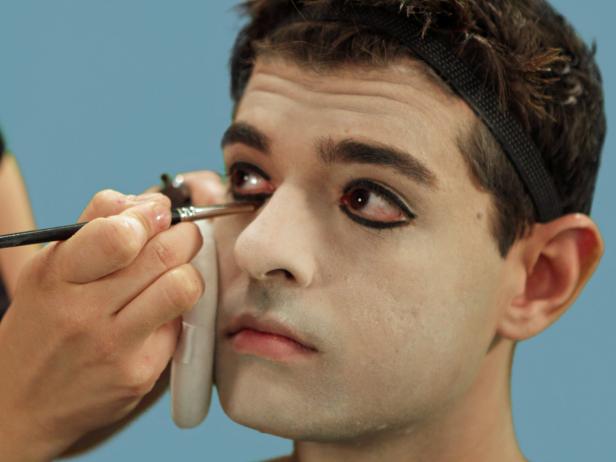 Use a black eyeliner pencil to heavily outline both upper and lower lids, from corner to corner. Use a flat makeup brush to apply black eye shadow over the eyeliner. This will diffuse the eye line and blend it out to create a smoky, dark look.