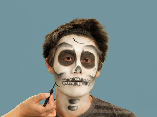 Complete your Halloween skeleton look with details. To add character to your skull, create a few cracks in the bone using liquid eyeliner. Add uneven lines at the forehead, on the cheek and chin