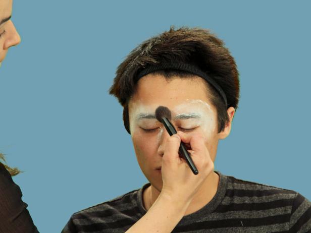 After using a glue stick to smooth down the eyebrows, use translucent powder to set the glue. First dab it on with a powder puff then brush away any excess.
