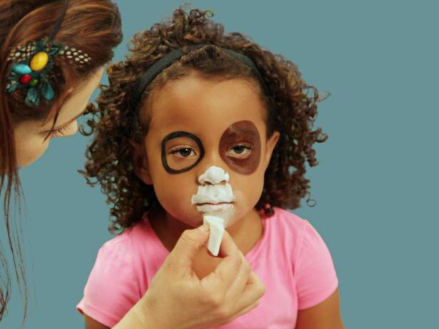 To create the puppy's mouth area, use white face paint on a makeup sponge to cover the tip of the nose, around the mouth and the lips.