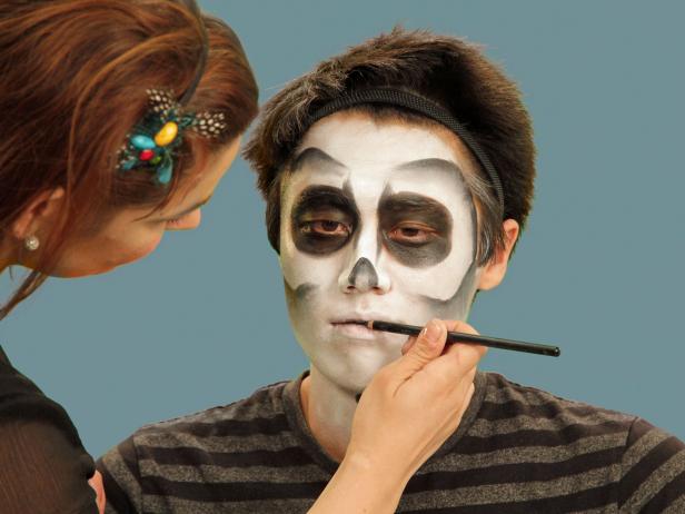 To make a mouth full of ghoulish teeth, use a black eyeliner pencil to line where the lips meet. Extend the natural lip line about two inches from the mouth on each side.