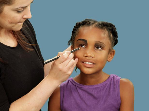 When creating your Halloween spider look, use an eye shadow brush and apply dark gray eye shadow to the eyelids. Use a black eyeliner pencil to create an exaggerated brow above just one eye. For a scarier spider look, use a black eyeliner pencil to line the bottom of the eyelids.