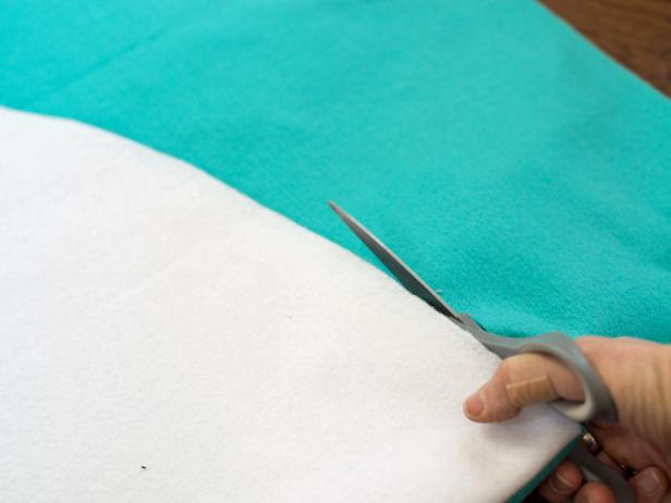 Using white Christmas tree skirt as a template, cut turquoise felt in a 48" circle.