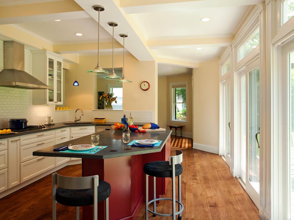 Neutral Kitchen With Red Island, Dark Countertops and Glass Pendants