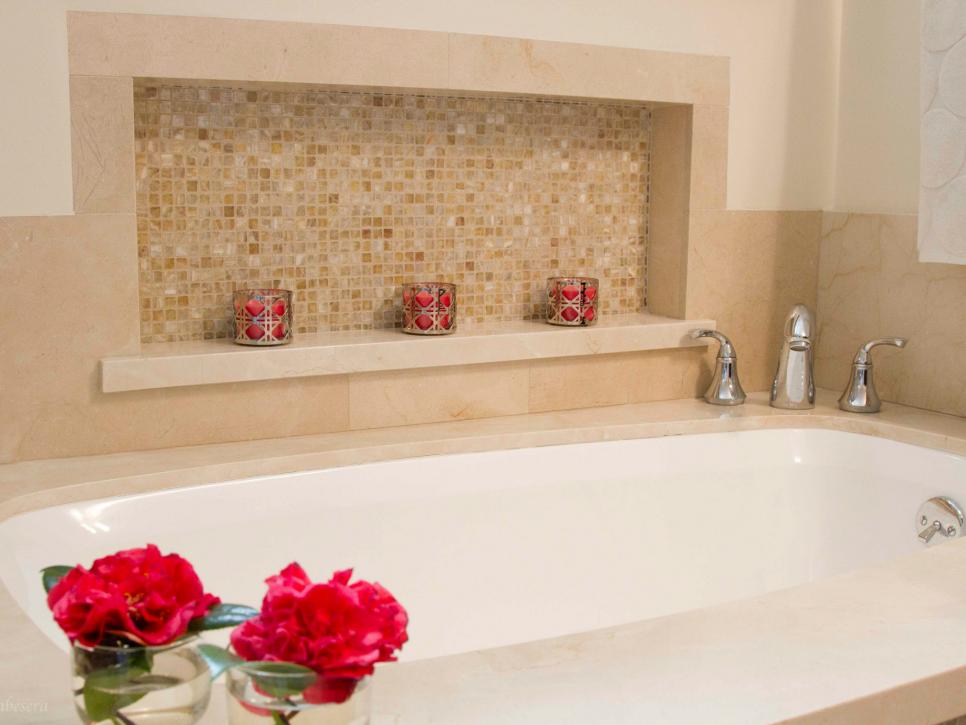 White Bathtub With Marble Tile Surround and Storage Ledge