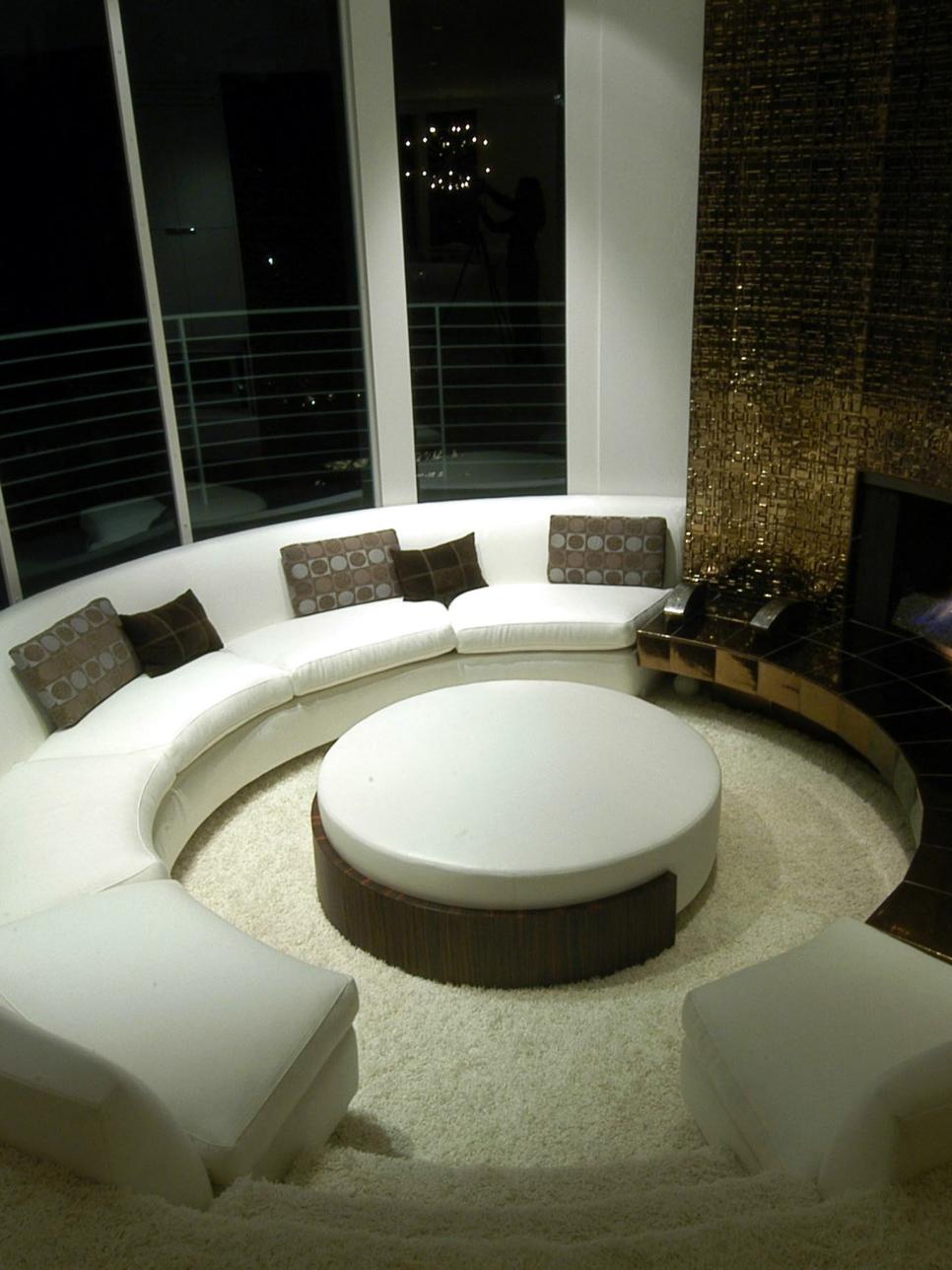 Living Room With Curved White Sofa and Metallic Fireplace Surround