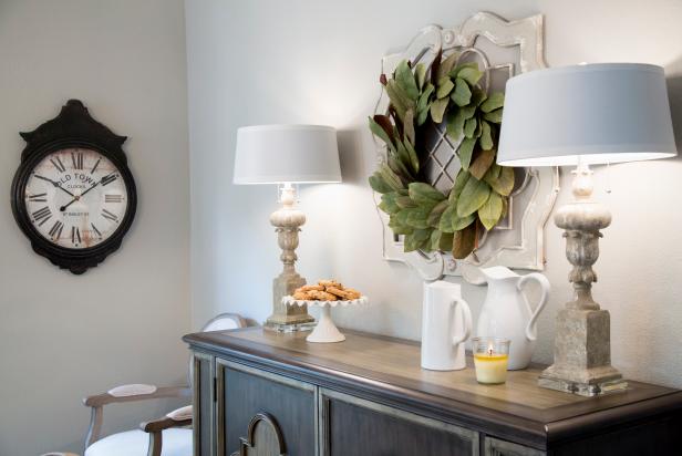Sideboard Details A Magnolia Wreath Between Two Lamps on a Wood Sideboard