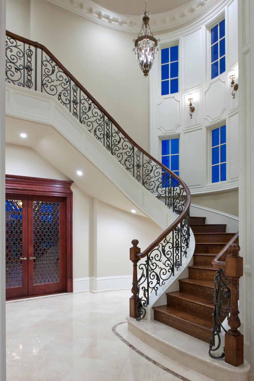 Opulent Foyer with Curving Staircase White Traditional Foyer