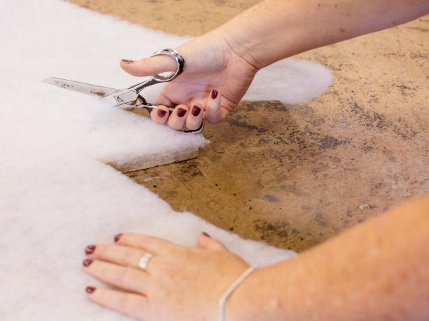 Spray adhesive onto the boardâs surface then roll out batting on top. Press into place, then trim neatly along the edges . To ensure batting stays put, staple once on each corner Repeat on either side of each board.