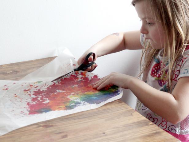 girl cutting wax paper rainbow art