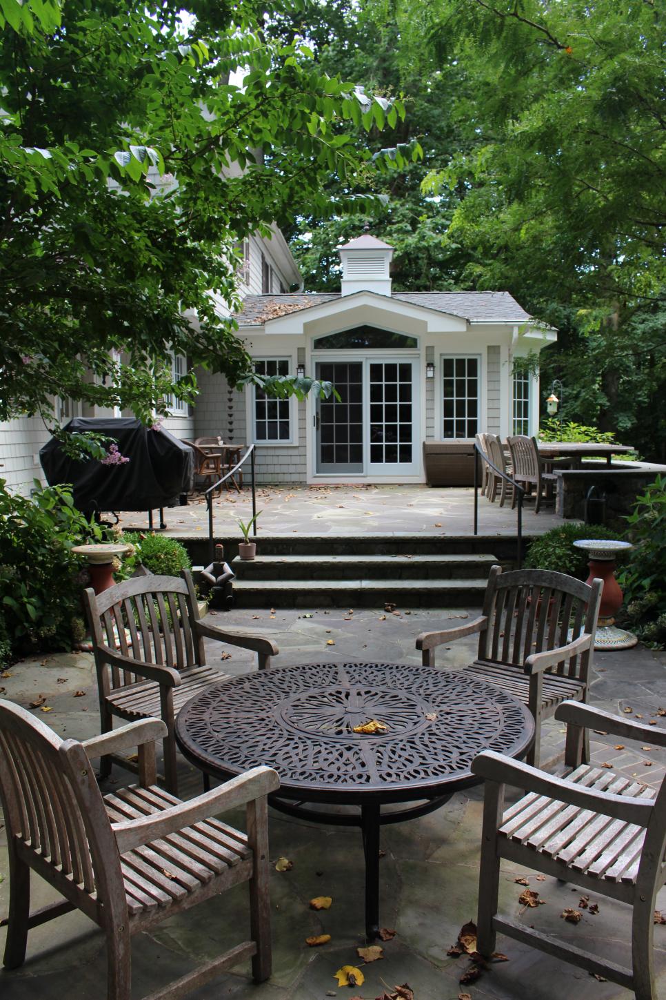Stone Terrace With Round Patio Table Shaded Patio With Round Table & Wooden Armchairs