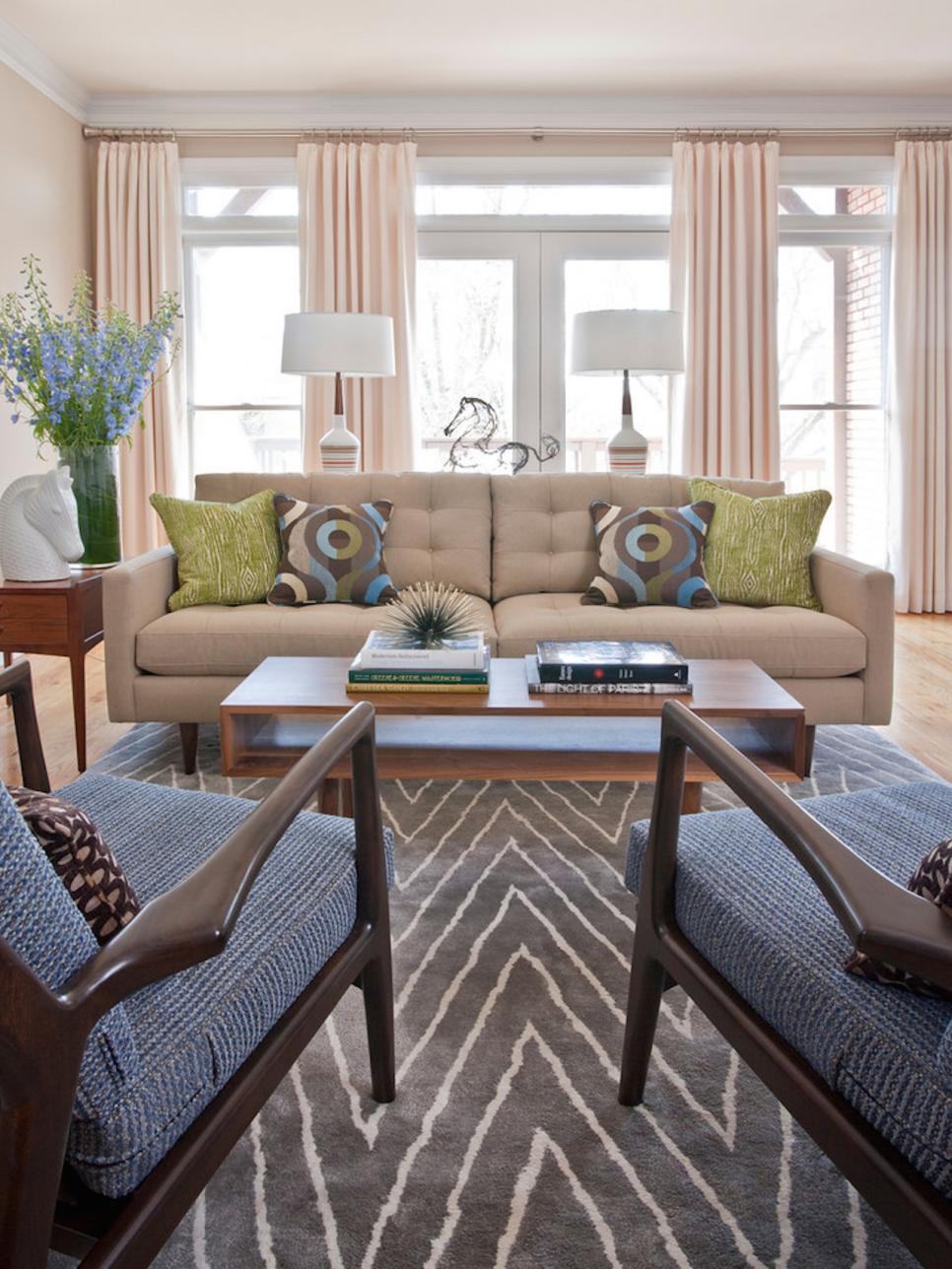 Pretty Accents in Midcentury Modern Living Room Neutral Living Room With Tan Sofa, Gray Rug, Graphic Pillows