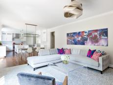 Gray Contemporary Living Area With Colorful Art and Lucite Table