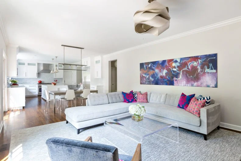 Gray Contemporary Living Area With Colorful Art and Lucite Table