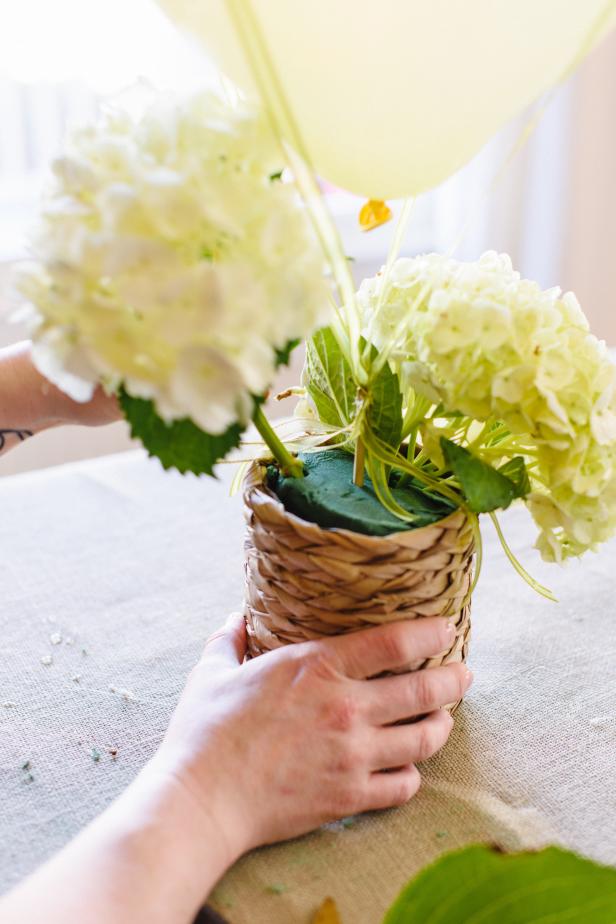 Add the cut flowers to complete the centerpiece by inserting the stems into the floral foam.