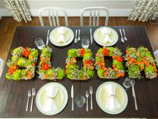 Say it with flowers! Create a stunning centerpiece using seasonal flowers and inexpensive papier mache letters.