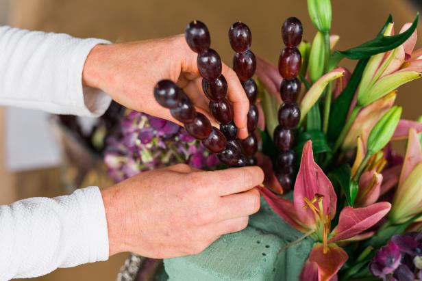 Insert all grape kebabs into the exposed floral foam along the top of the urn. Make sure they’re placed closely enough together to mask any of the green foam peeking through.