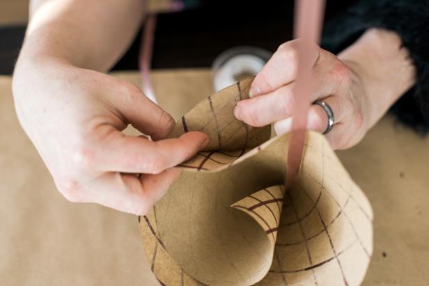 Tape the loose ends of the paper cone to the inside of the shape using double-sided tape. Secure the cone shape by pushing the paper against the tape inside the cone.