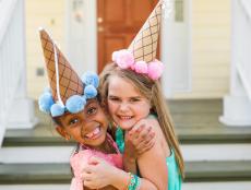 Two Girls Hugging With Paper Cone Party Hats