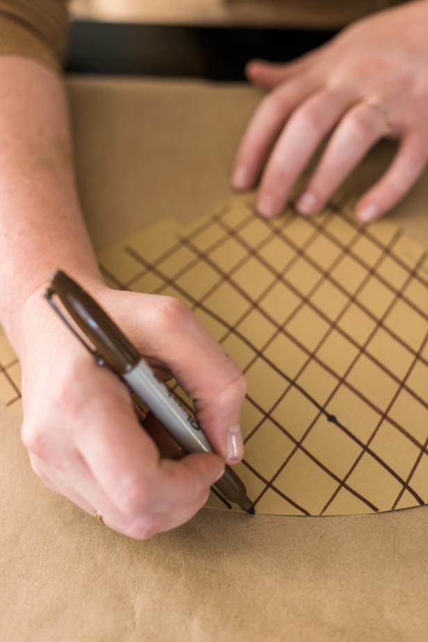 Draw a diamond pattern on the paper with a brown marker. Draw parallel lines along the paper, rotate and draw more parallel lines.