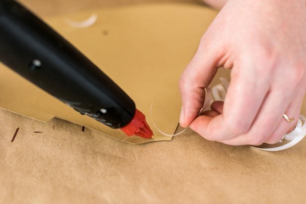 Cut three 12" pieces of ribbon. Drag them across the edge of the scissors to curl. Glue the curled ribbon to the top of the cone.