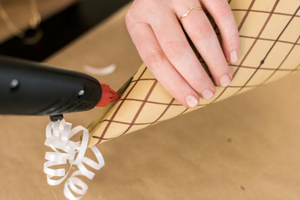 Insert the tab into the slit to form the cone. Use the hot glue gun to glue the cone shut.