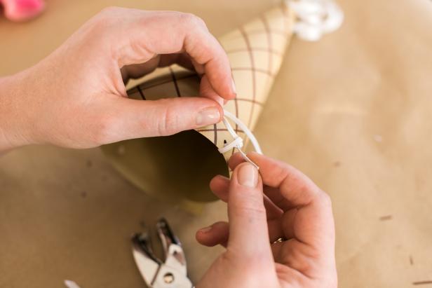Cut a 12" length of elastic and insert into the holes near the bottom of the cone. Tie off each of the ends to form a chinstrap.