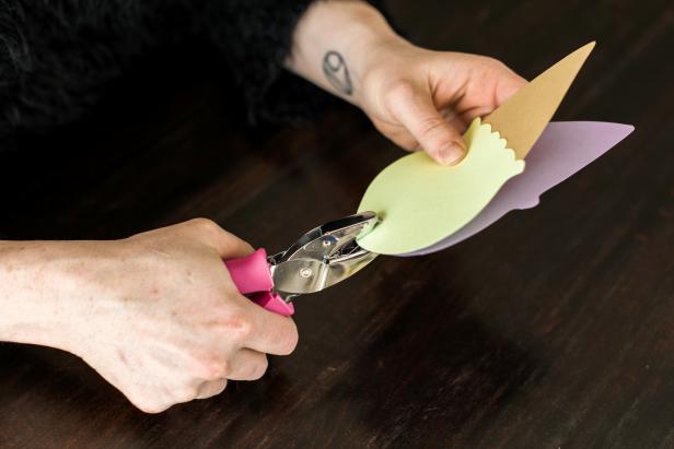 Place the glued scoop and cone shape on top of the solid ice cream cone shape and punch a hole in the top. TIP: Use the felt tip pen to write the party details on the inside of the solid ice cream cone shape.