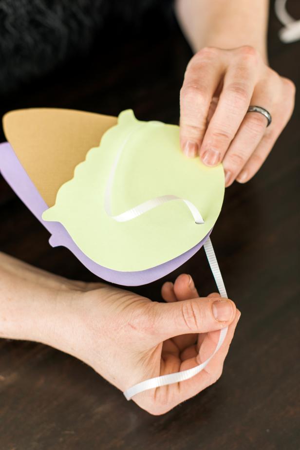 Cut a 12" length of ribbon and put it through hole in the top of the invitation. Tie the ends together and curl.