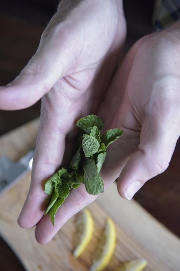 Rub the mint leaves in your hands to release their fragrance, add them to the cocktail glass and muddle again.