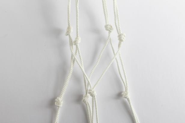 Lay your knots down flat next to each other. Knot together the 2nd and 3rd piece of rope, the 4th and 5th pieces of rope, and the 6th and 7th pieces of rope using an overhand knot. Knot together the 1st and 8th piece of rope. This second set of knots will sit in the middle of your planter, so be sure to make the length between the first set of the knots and the second set match your planter. For example, if you are using a 10â tall pot, the space between each knot should be 5â.