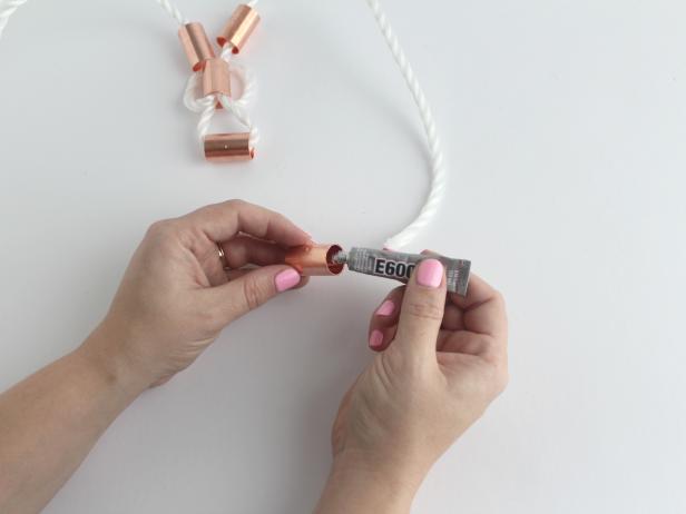 Using the glue, attached the ends of the rope into the last copper piece. Put the left rope end into the left side of the piece.