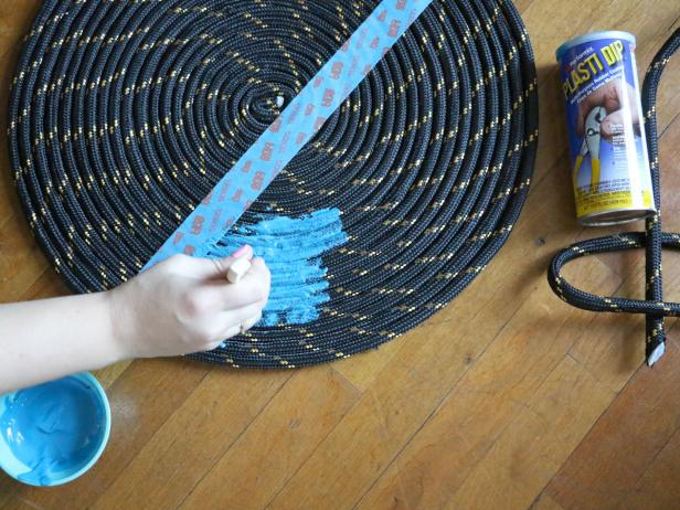 Use the Plasti Dip as paint and cover one side of the rope rug. Use a few coats to completely cover the rope. Take off the tape and let dry.
