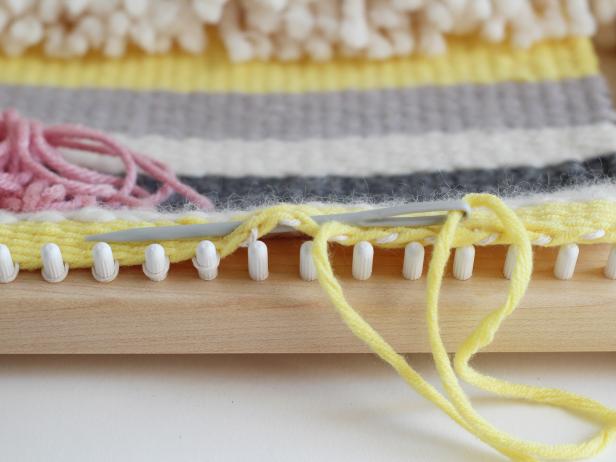 Letâs finish the bottom of the tapestry first. Thread the loose end of your first color through the tapestry needle. As you pull the warp off of the loom, weave the end through the tapestry.