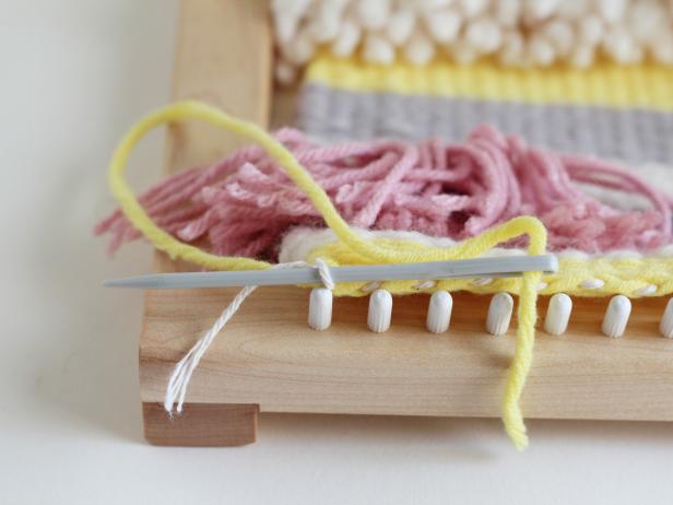 Letâs finish the bottom of the tapestry first. Thread the loose end of your first color through the tapestry needle. As you pull the warp off of the loom, weave the end through the tapestry.