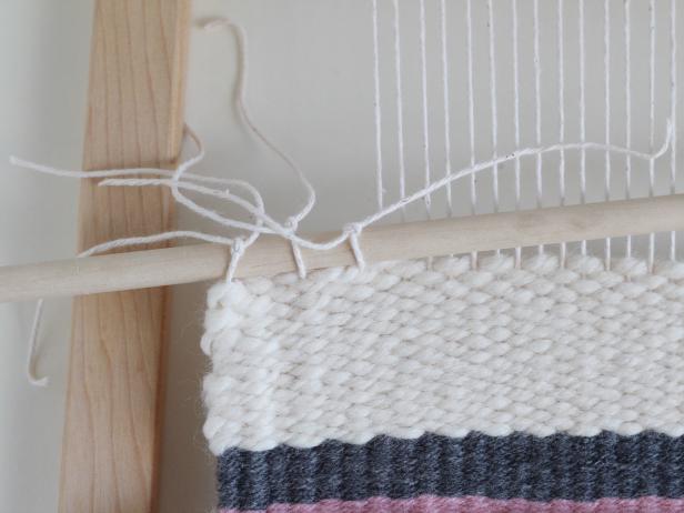 Wall Tapestry Grab the dowel. Cut the first two warp threads off the loom and tie them around the dowel. Cut the next two warp threads and tie them around the dowel. Continue like this all the way across the tapestry. Trim the ends of the knots.