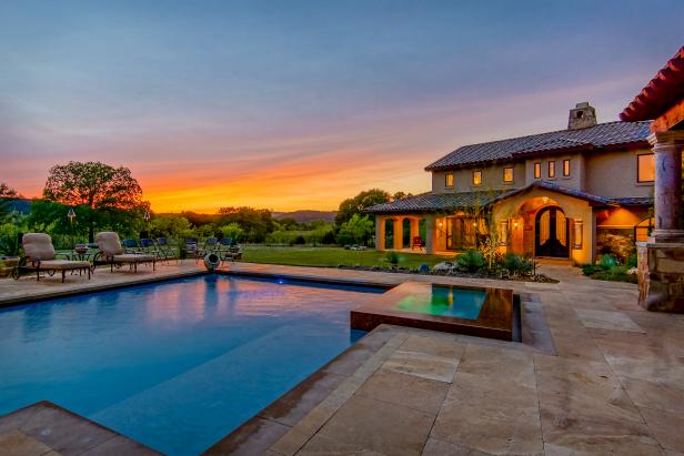 Sun Sets Behind Stucco Home With Tiled Roof