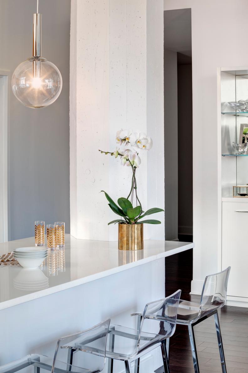 Modern White Kitchen Bar With Lucite Barstools and Gold Accents