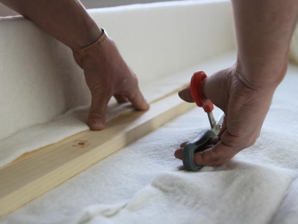 Pull tightly ensuring that there are no wrinkles on the face of the cornice, and staple on the interior edge of the cornice box.