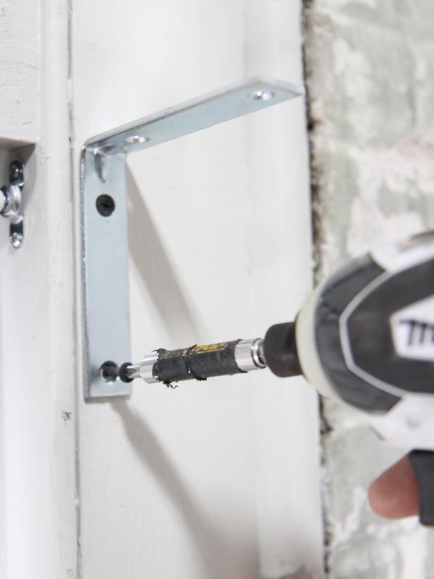 Use 2â wood screws to attach the âLâ bracket to the window frame.