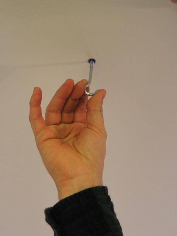 Insert and screw in a #10 screw hook.