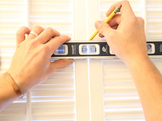 Place a level on the mark from step 11 and use a pencil to draw a perfect horizontal line on each side of the shutter frame.