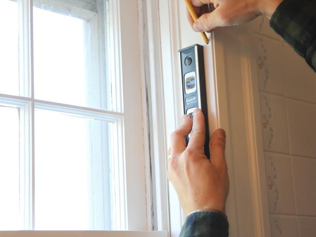Hold up one of the filler strips to the front edge of the window frame, level and mark the screw holes with a pencil.