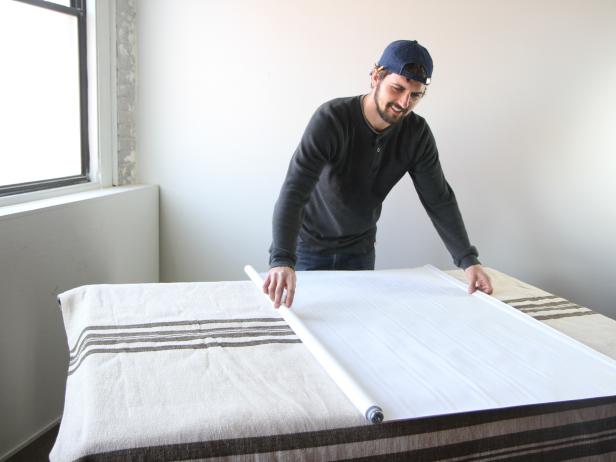 On a large flat work-surface, roll the shade out.