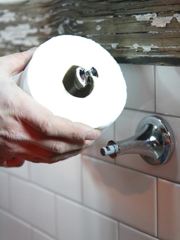 Slide the toilet paper roll on to the left side pivot arm.